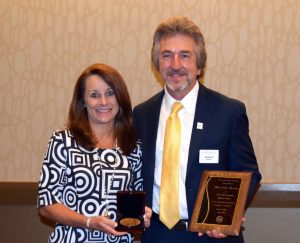 Mary Burlseon, President of Whitman Publishing, accepts the 2016 Elvira Clain-Stefanelli Memorial Award for Achievement in Numismatics alongside Jeff Garrett, Senior Editor of the Red Book.