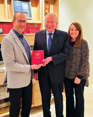 John Feigenbaum, Charles Anderson, and Mary Burleson on November 1, 2023 holding the original Red Book the day after CDN Publishing acquired Whitman Publishing